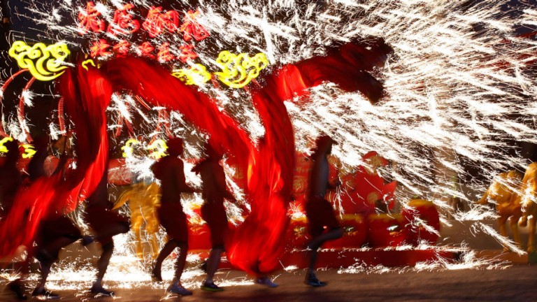 Dancers perform a fire dragon dance in the shower of molten iron spewing firework-like sparks during a folk art performance to celebrate the traditional Chinese Spring Festival on the first day of the Chinese Lunar New Year, which welcomes the Year of the Horse, at the Happy Valley amusement park in Beijing January 31, 2014