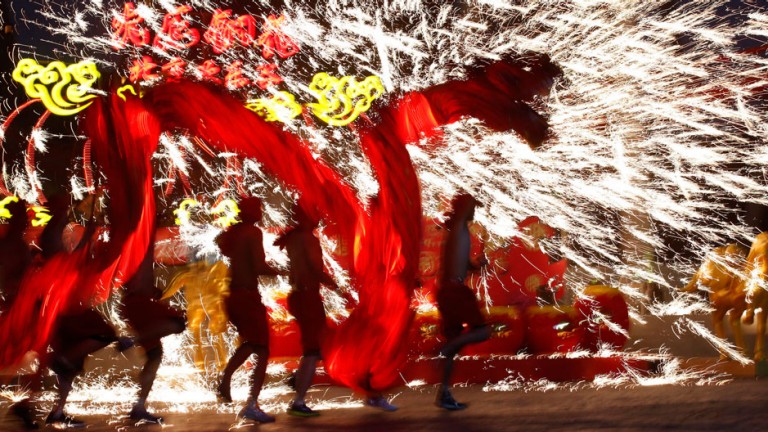 Dancers perform a fire dragon dance in the shower of molten iron spewing firework-like sparks during a folk art performance to celebrate the traditional Chinese Spring Festival on the first day of the Chinese Lunar New Year, which welcomes the Year of the Horse, at the Happy Valley amusement park in Beijing January 31, 2014