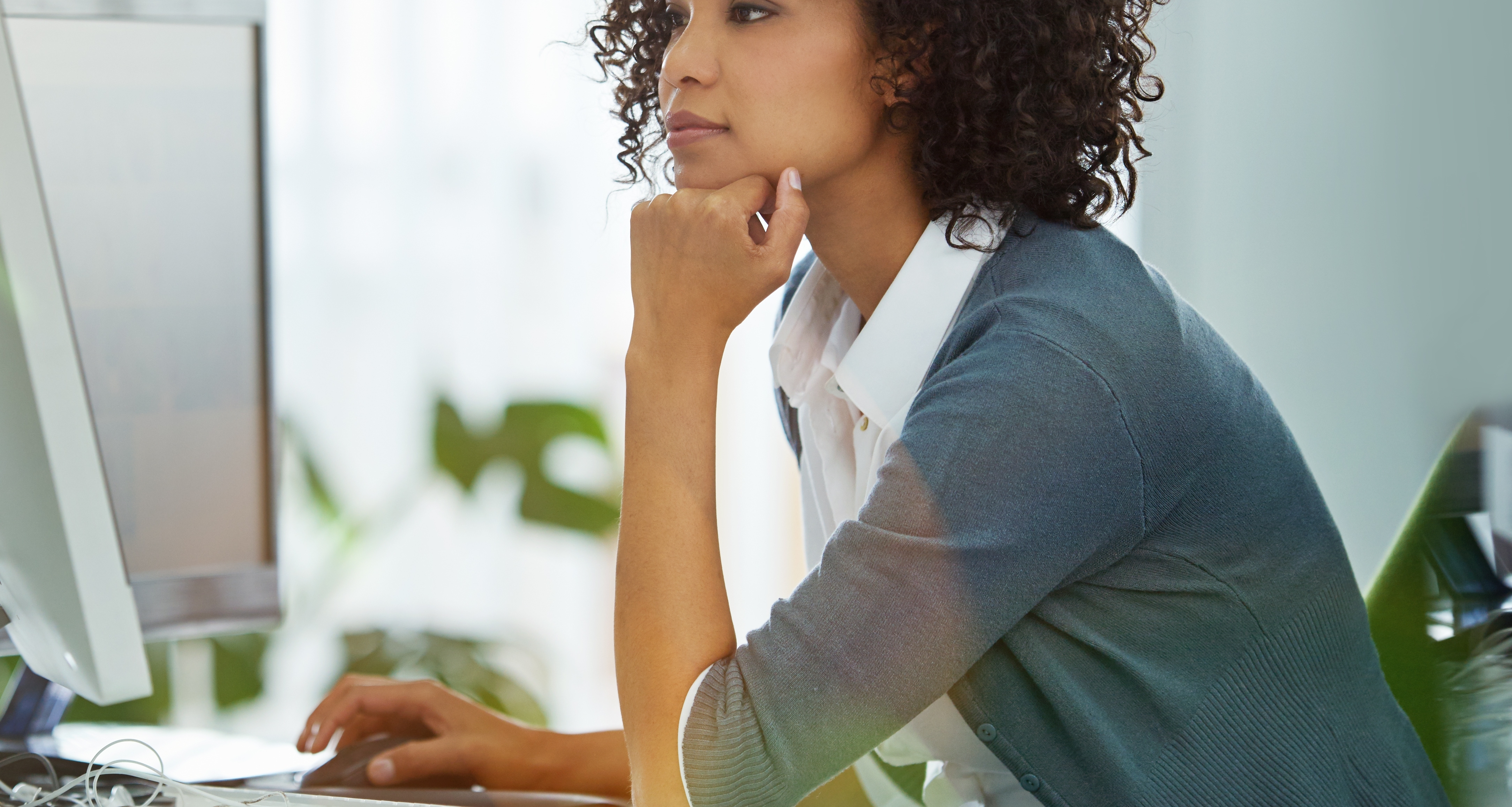 Shot of a young designer deep in thought while working on a computer in a modern office