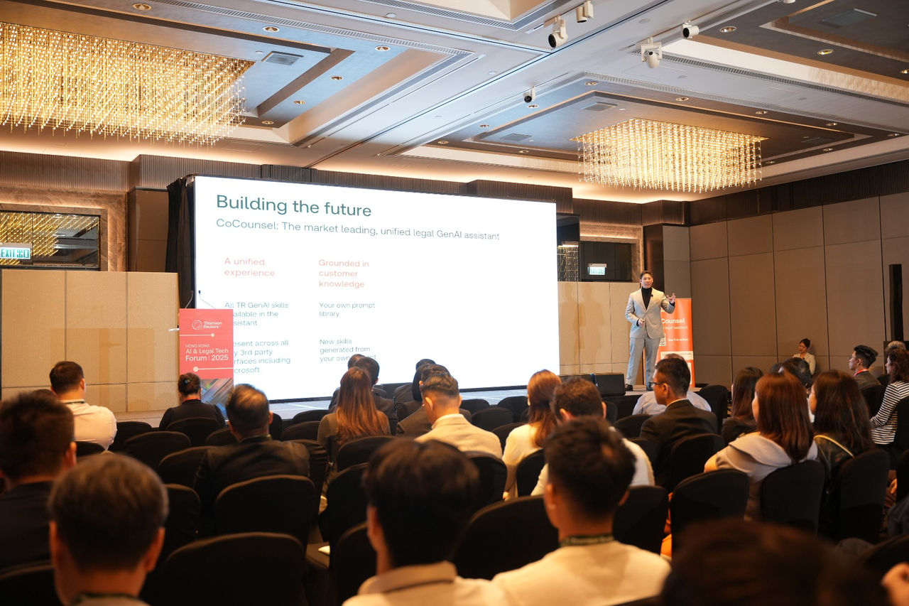 Speaker presenting onstage to an audience during a session on building the future of legal technology.